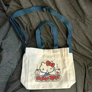 Hello Kitty white canvas tote with blue handles.